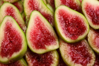 Photo of Pieces of fresh green figs as background, top view