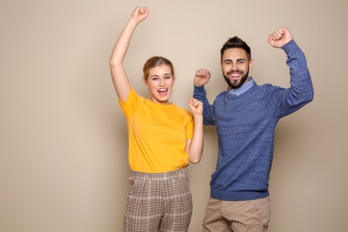 Photo of Happy young people celebrating victory on color background