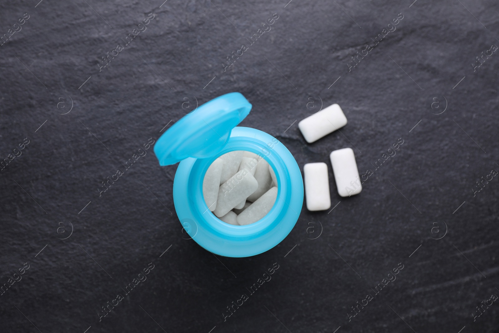 Photo of Jar with chewing gums on black table, flat lay