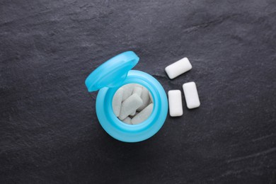 Photo of Jar with chewing gums on black table, flat lay