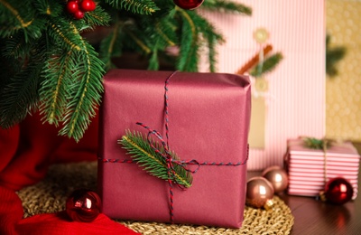 Photo of Beautifully wrapped gift box and Christmas decor on wicker mat