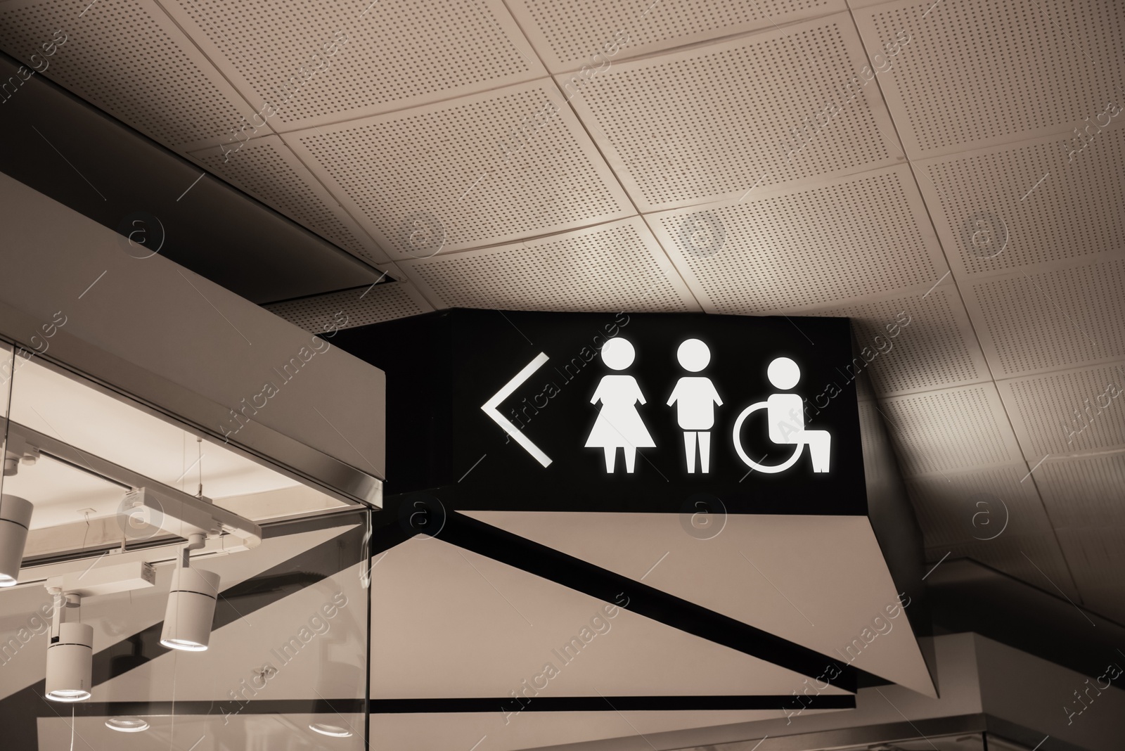 Image of Symbols and arrow on black sign in mall near public toilet