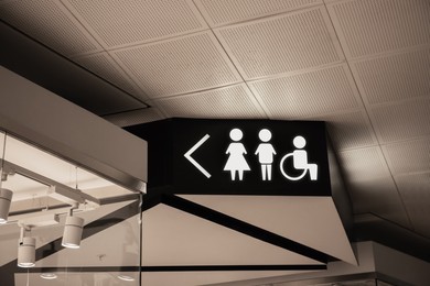 Image of Symbols and arrow on black sign in mall near public toilet