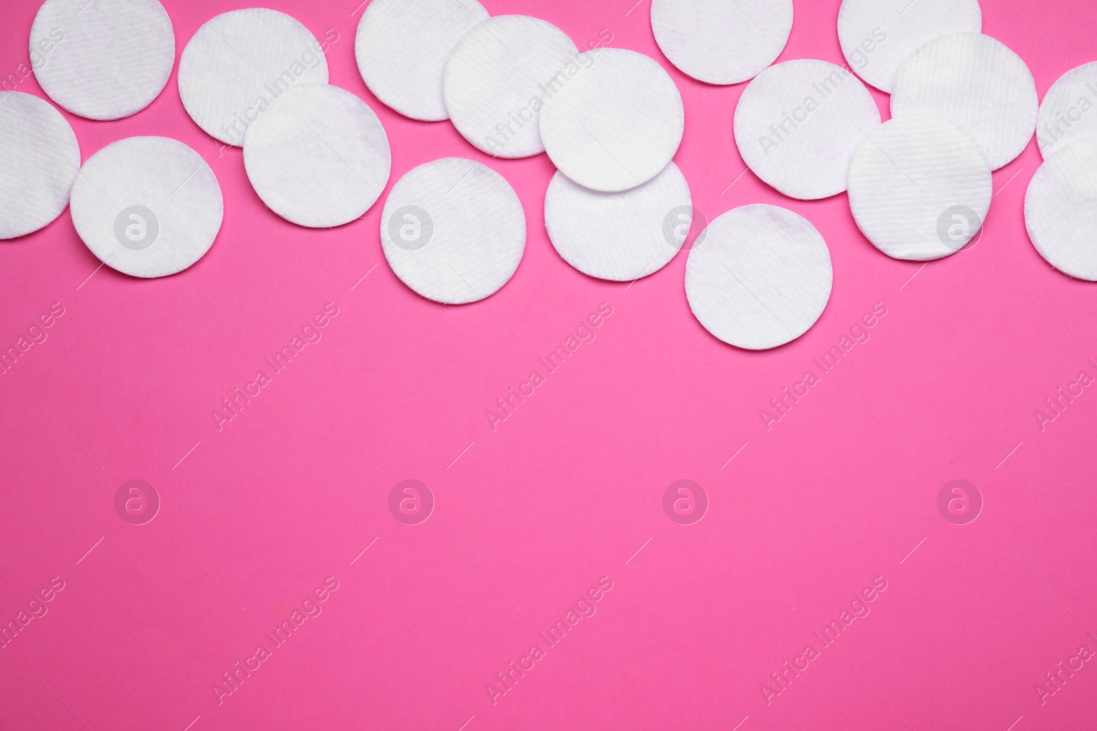 Photo of Many cotton pads on pink background, flat lay. Space for text