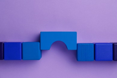 Photo of Bridge made of colorful blocks on violet background, flat lay. Connection, relationships and deal concept