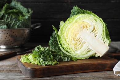 Photo of Cut fresh savoy cabbage on wooden table