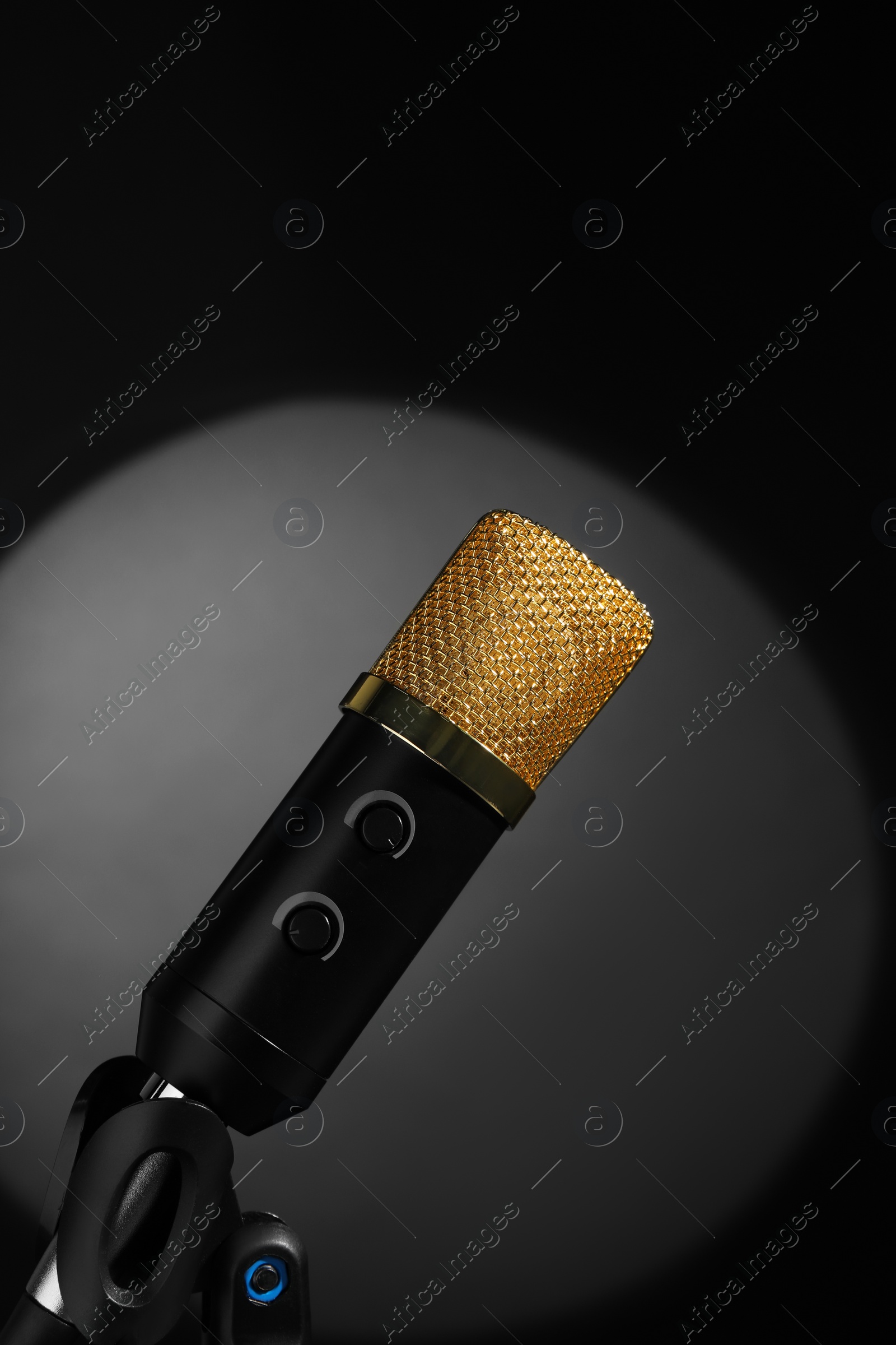 Photo of Microphone in spotlight on black background. Sound recording and reinforcement