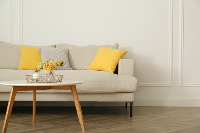 Photo of Stylish beige sofa in living room interior