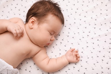 Photo of Cute little baby sleeping in crib at home, top view. Space for text