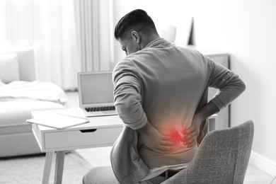 Image of Man suffering from back pain at workplace. Bad posture problem
