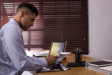 Photo of Businessman working with tablet and chart in office, space for text. Forex trading