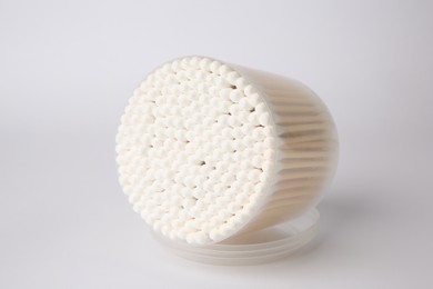 Photo of Open container with cotton buds on white background