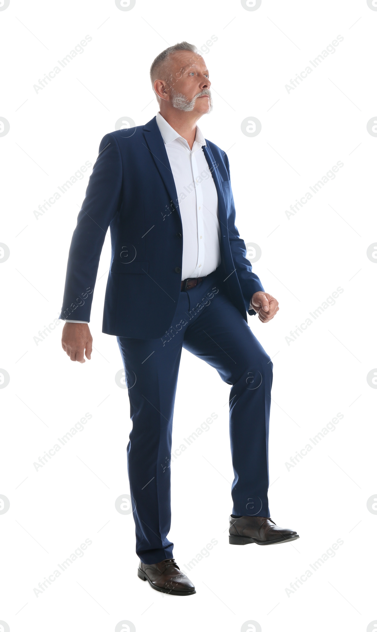 Photo of Businessman imitating stepping up on stairs against white background. Career ladder concept