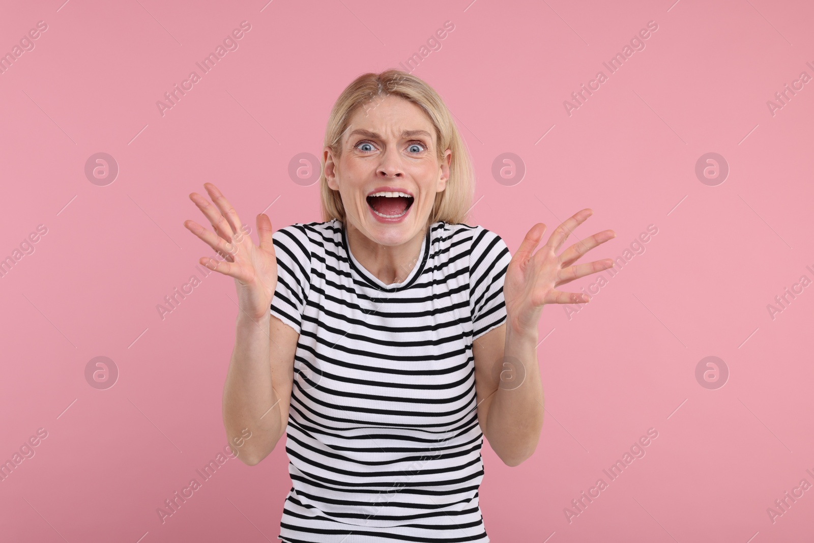 Photo of Portrait of surprised woman on pink background