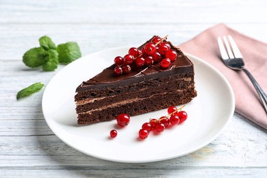 Plate with slice of chocolate cake and berries on table