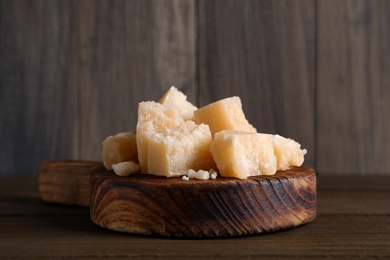 Pieces of delicious parmesan cheese on wooden table, closeup