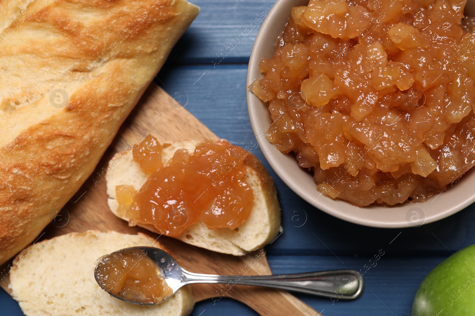 Photo of Flat lay composition with delicious apple jam on blue wooden table
