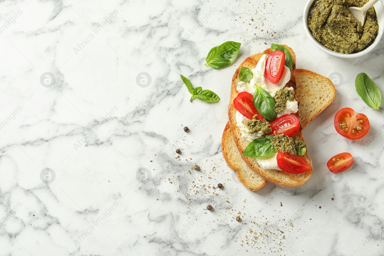 Photo of Toasted bread with tasty cream cheese and tomatoes on marble table, flat lay. Space for text