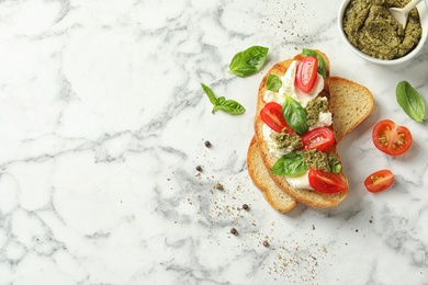 Toasted bread with tasty cream cheese and tomatoes on marble table, flat lay. Space for text