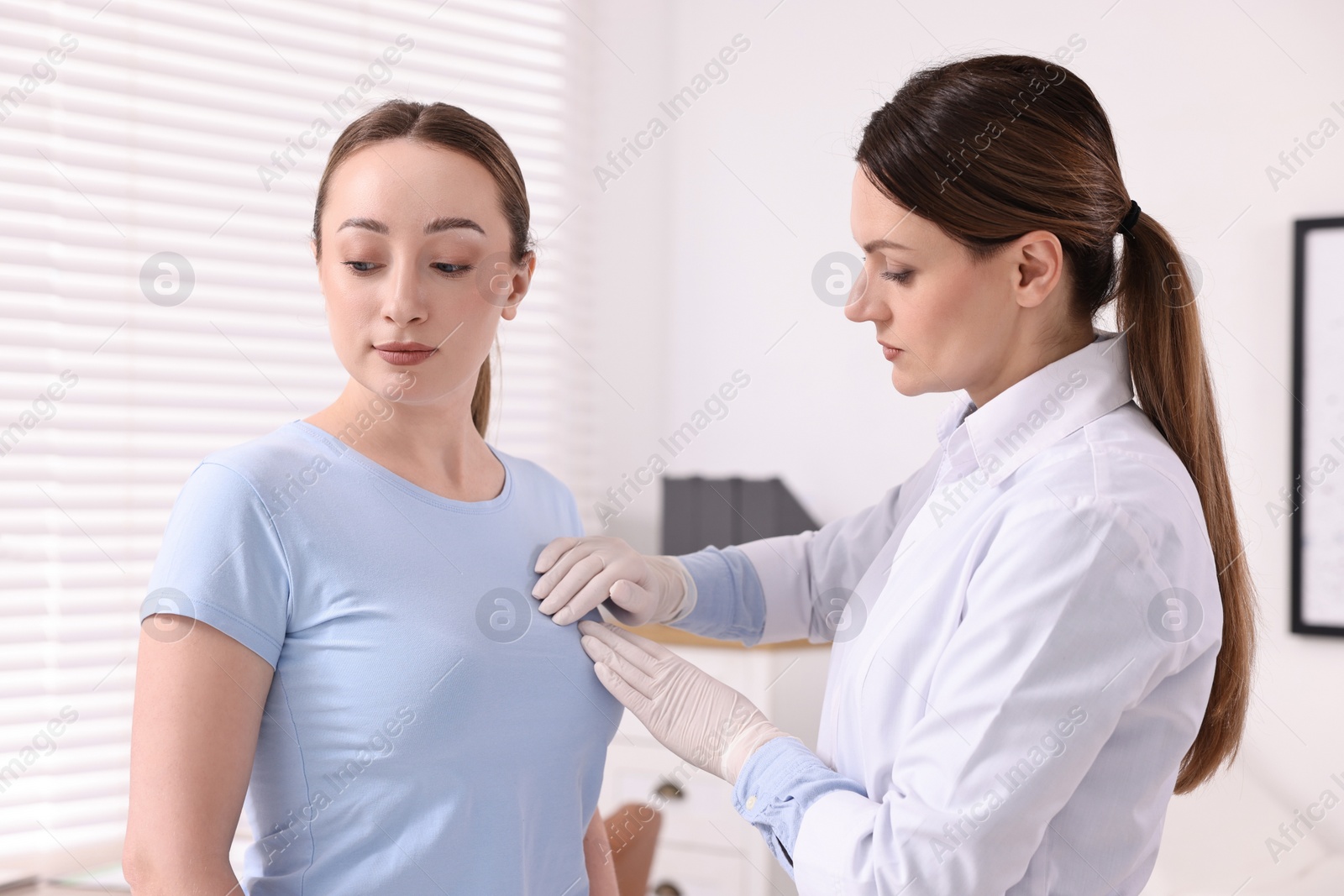 Photo of Mammologist checking young woman's breast in hospital