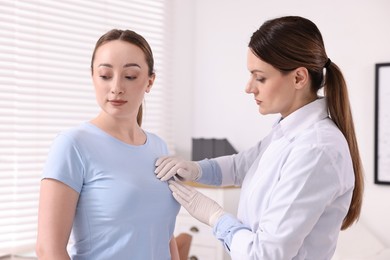 Mammologist checking young woman's breast in hospital