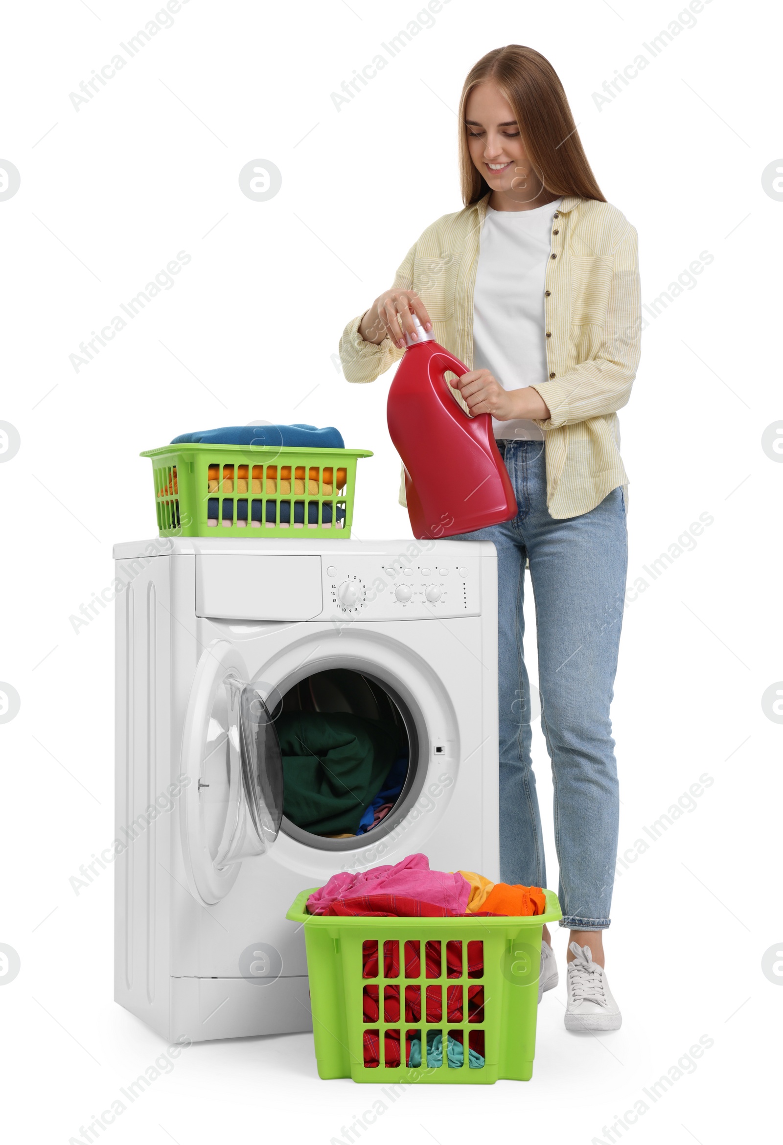 Photo of Beautiful young woman with detergent and laundry near washing machine on white background