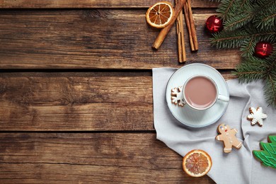 Photo of Flat lay composition with delicious hot chocolate and Christmas decor on wooden table, space for text