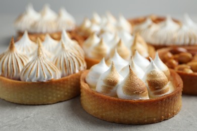 Photo of Many tartlets on grey table, closeup. Delicious dessert