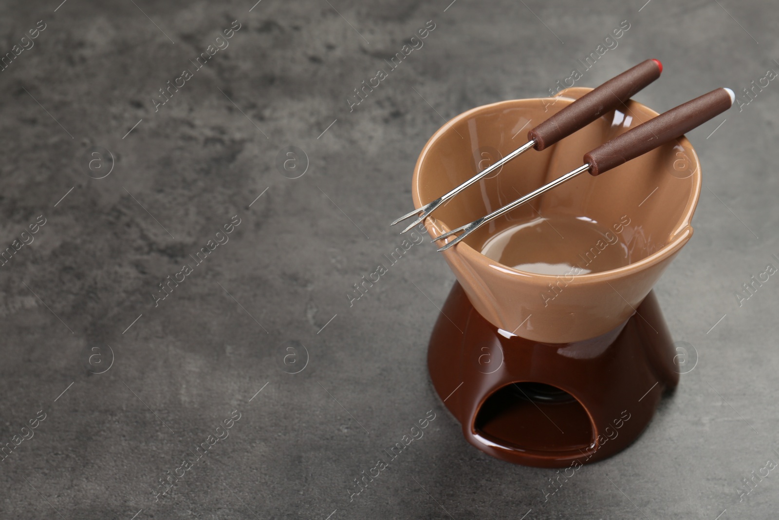 Photo of Fondue set on grey textured table, space for text