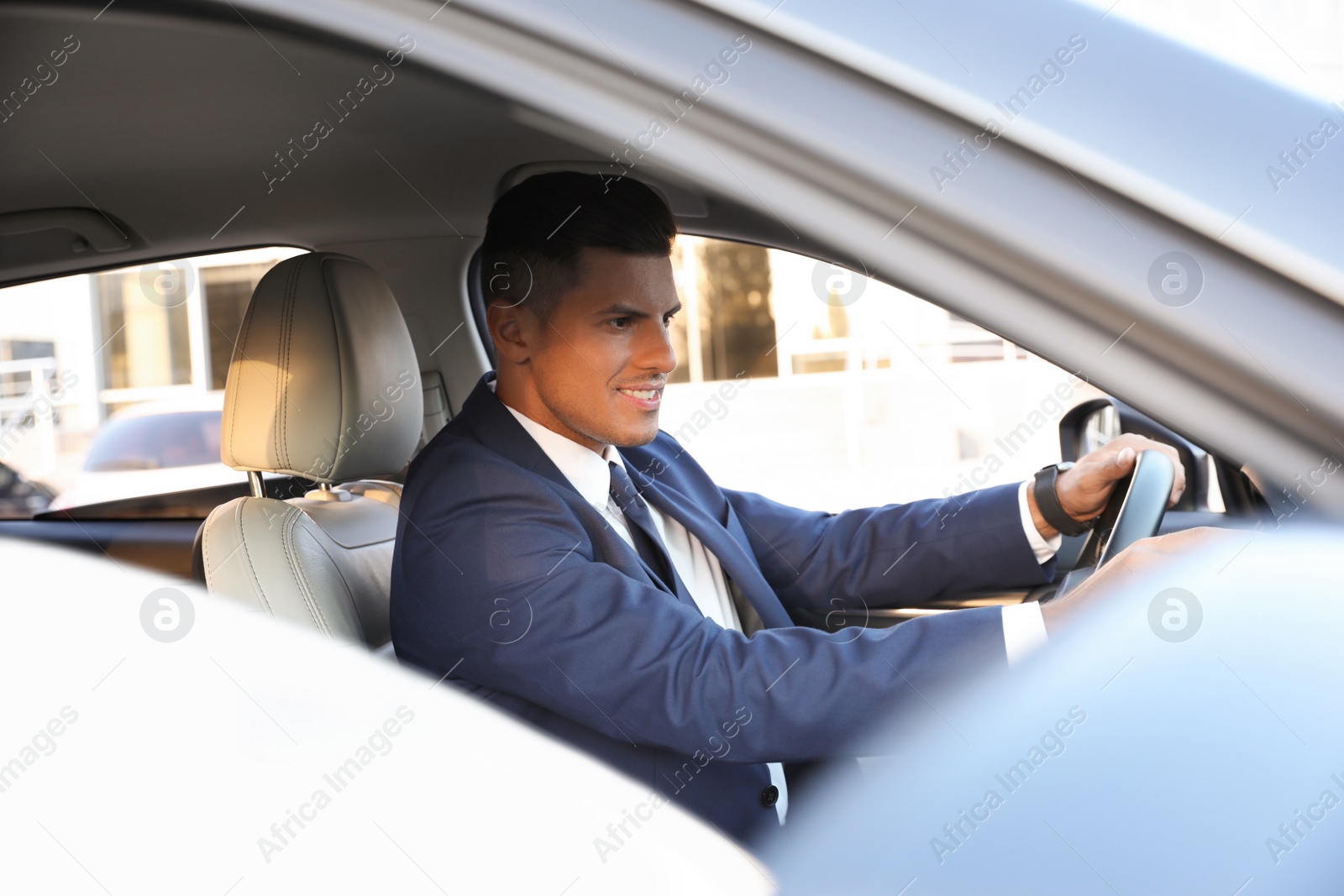 Photo of Handsome man driving his modern car, view from outside