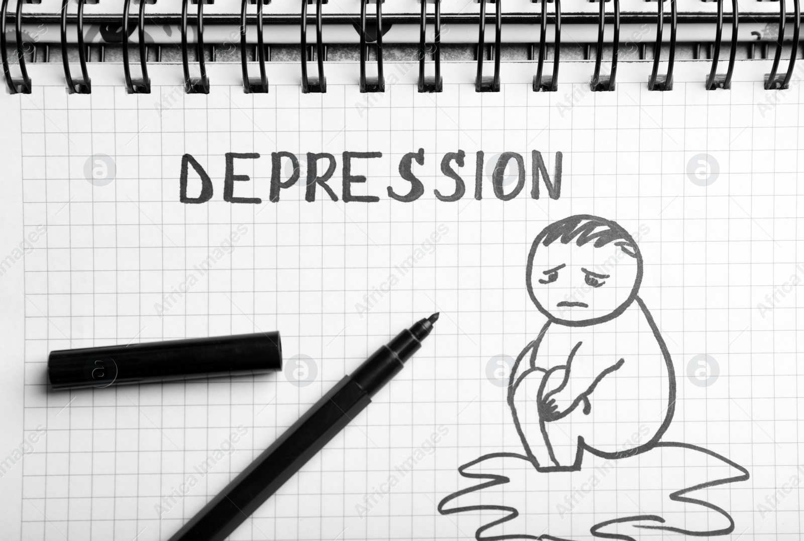 Photo of Drawing of sad man, word Depression and black felt tip pen on notebook, top view