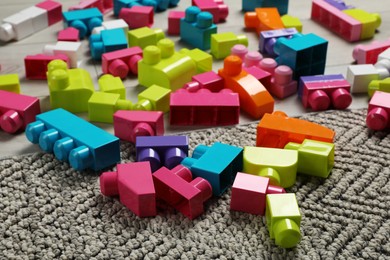 Photo of Colorful plastic building blocks on grey carpet