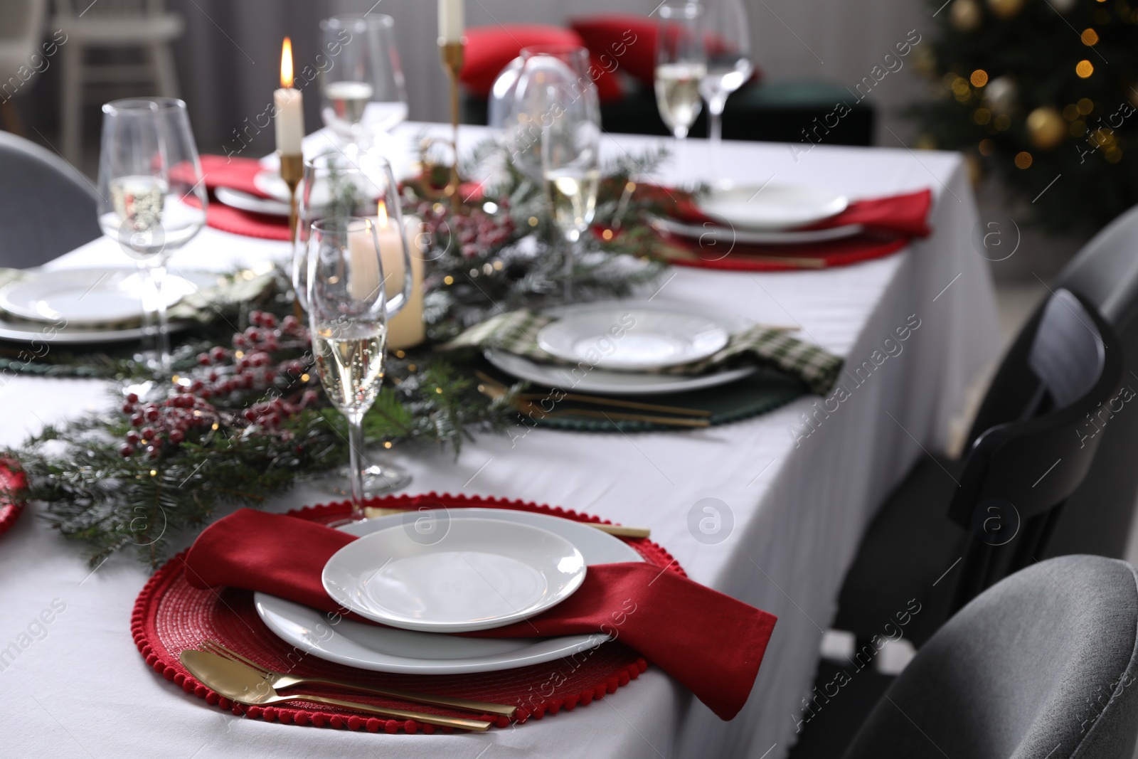 Photo of Christmas table setting with festive decor and dishware indoors