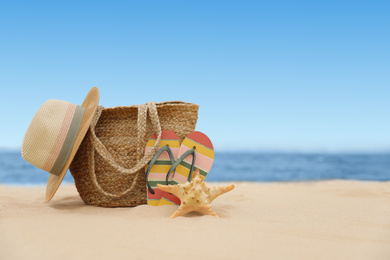 Bag and beach objects on sand near sea, space for text