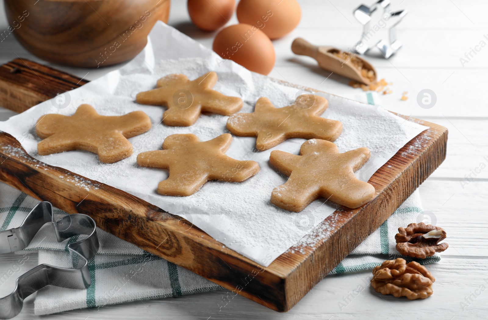 Photo of Making homemade Christmas cookies. Dough for gingerbread man on white wooden table