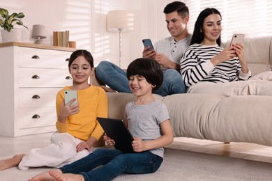 Photo of Internet addiction. Family with different gadgets in living room