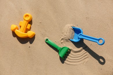 Set of plastic beach toys on sand, flat lay. Outdoor play