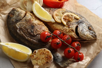 Photo of Delicious dorado fish with vegetables served on table, closeup