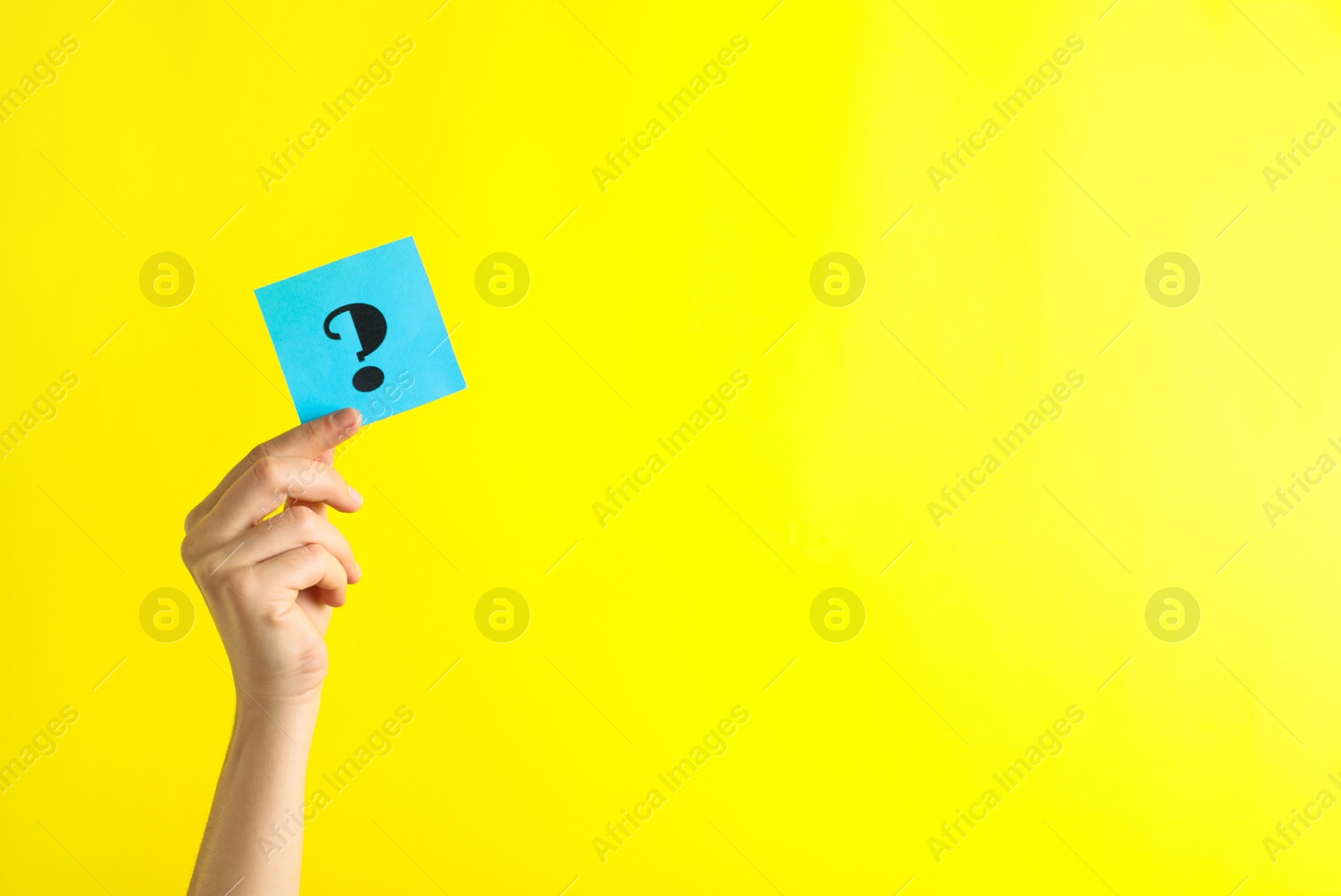 Photo of Woman holding note with question mark on yellow background, closeup. Space for text