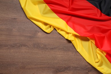 Photo of Flag of Germany on wooden background, top view. Space for text