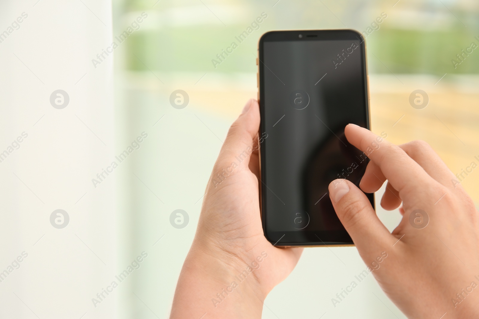 Photo of Woman working with modern smartphone indoors, closeup. Space for design