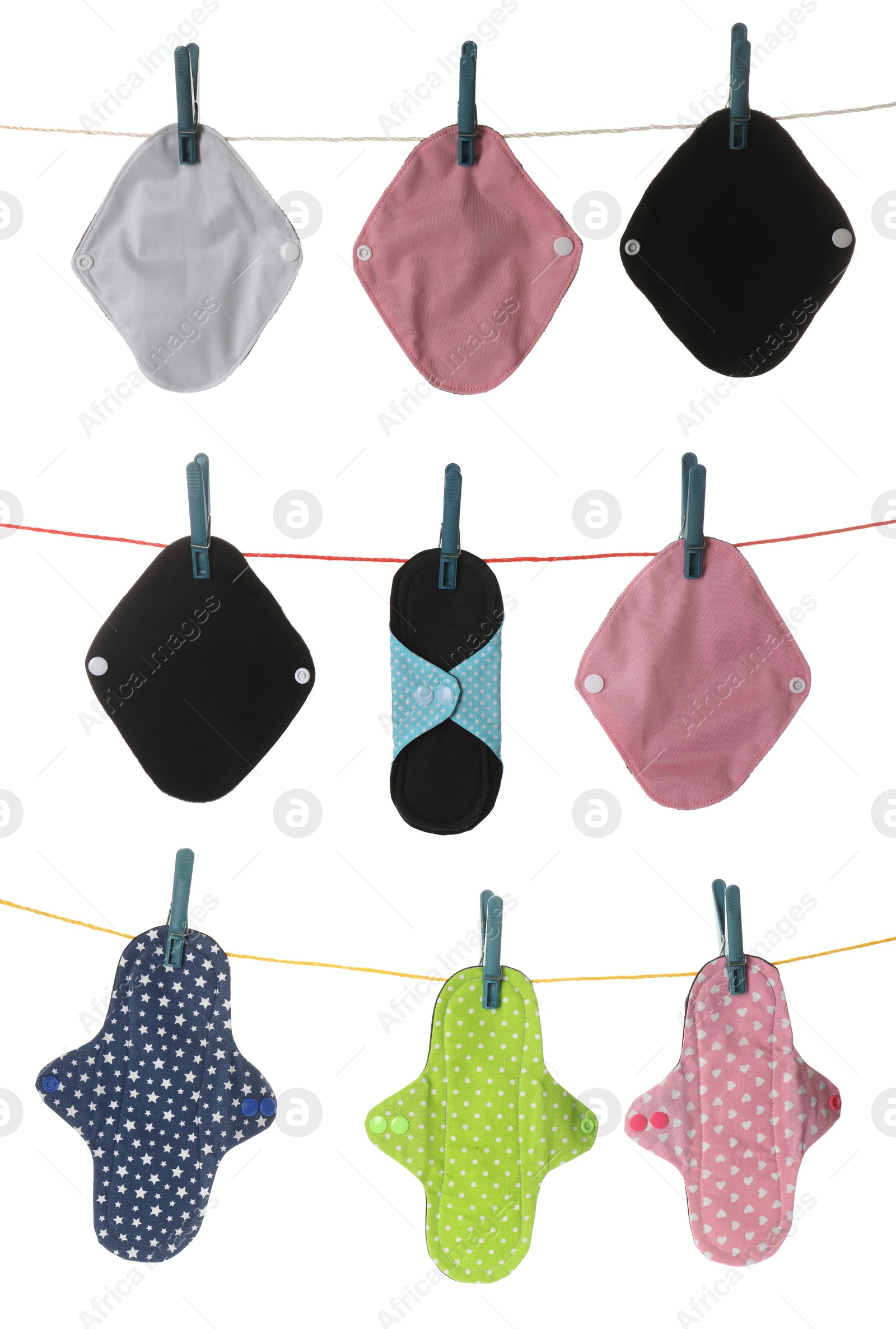 Image of Many different cloth menstrual pads hanging on laundry line, white background