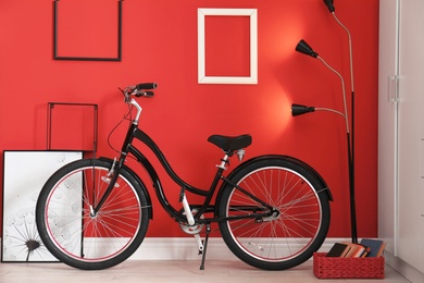 Photo of Stylish interior with bicycle at red wall