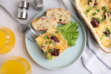 Photo of Tasty sausage casserole served on light grey table, flat lay