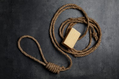 Photo of Rope noose and soap bar on grey table, flat lay