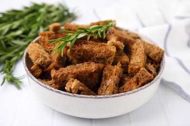 Crispy rusks with rosemary on white tiled table