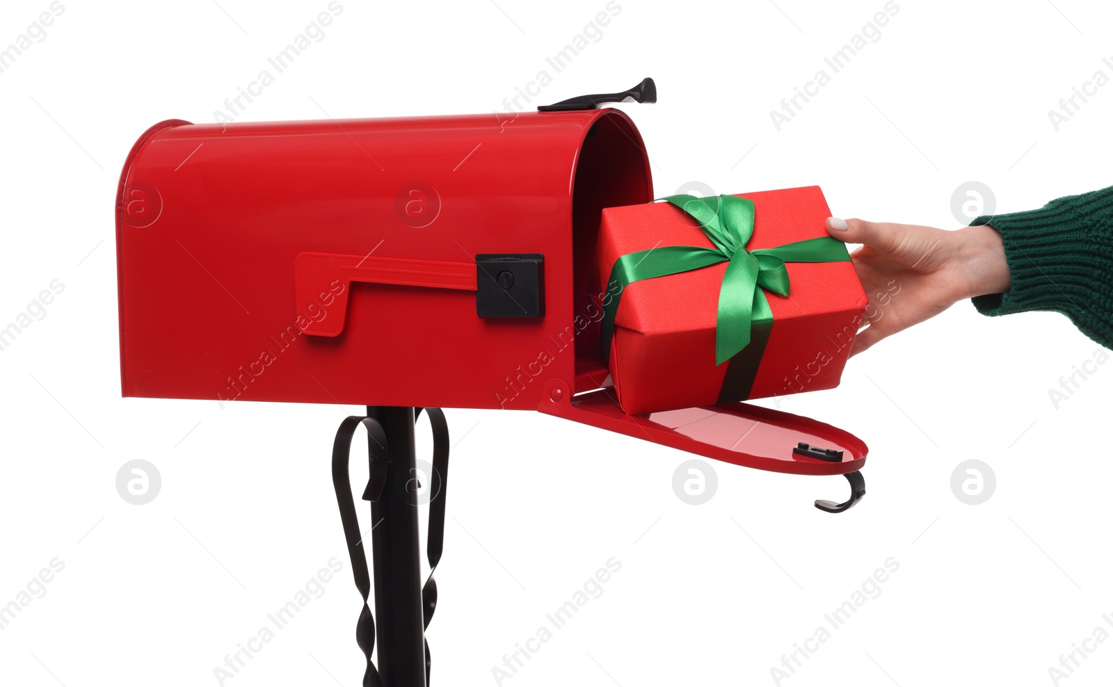 Photo of Woman putting Christmas gift into mailbox on white background, closeup. Sending present by mail