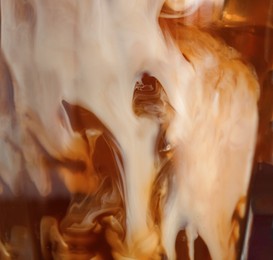 Photo of Glass with cold coffee and milk, closeup