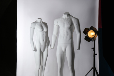 Photo of Ghost mannequins and professional lighting equipment in modern photo studio