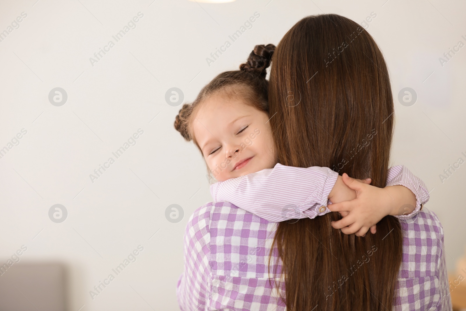 Photo of Young mother with little daughter at home. Space for text